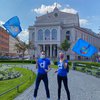 Zwei Mitglieder*innen von diversity München schwenken diversity-Fahnen am Gärtnerplatz in München anlässlich des IDAHOBIT* 2020.